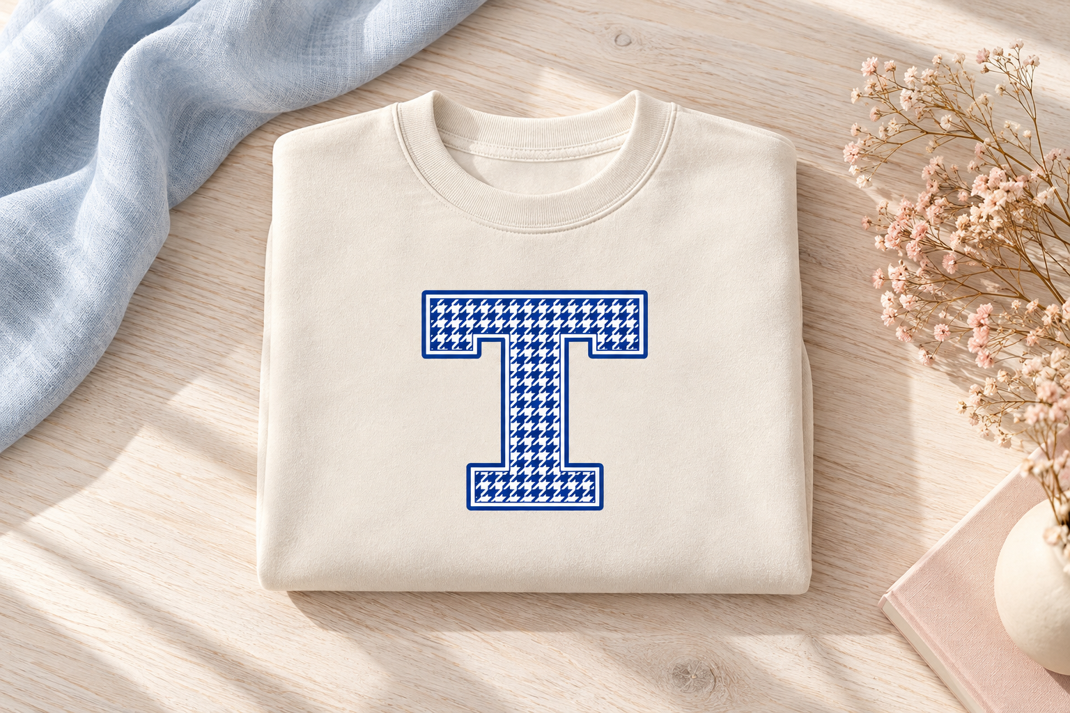 Bone crop crewneck with a blue houndstooth T, folded on a light wood table